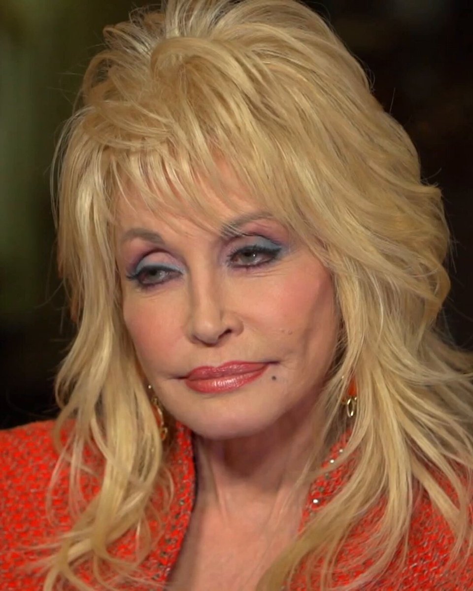Dolly Parton in a red jacket, from a clip shared by Adam Parkhomenko.