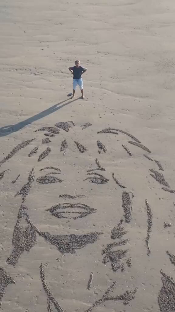 A Dutch beach artist raking a 20-meter portrait of Dolly Parton in the sand.